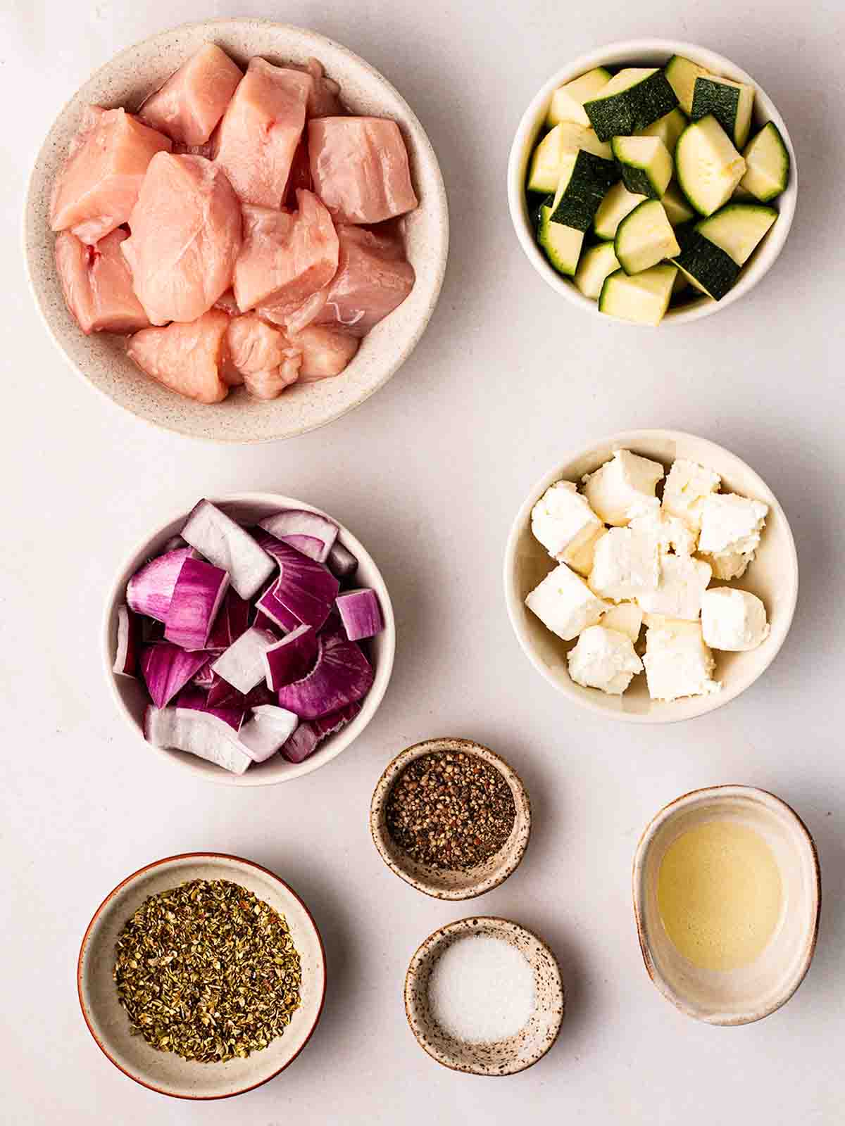 The ingredients for Air Fryer Greek Chicken Traybake chopped up and laid out on a counter top.